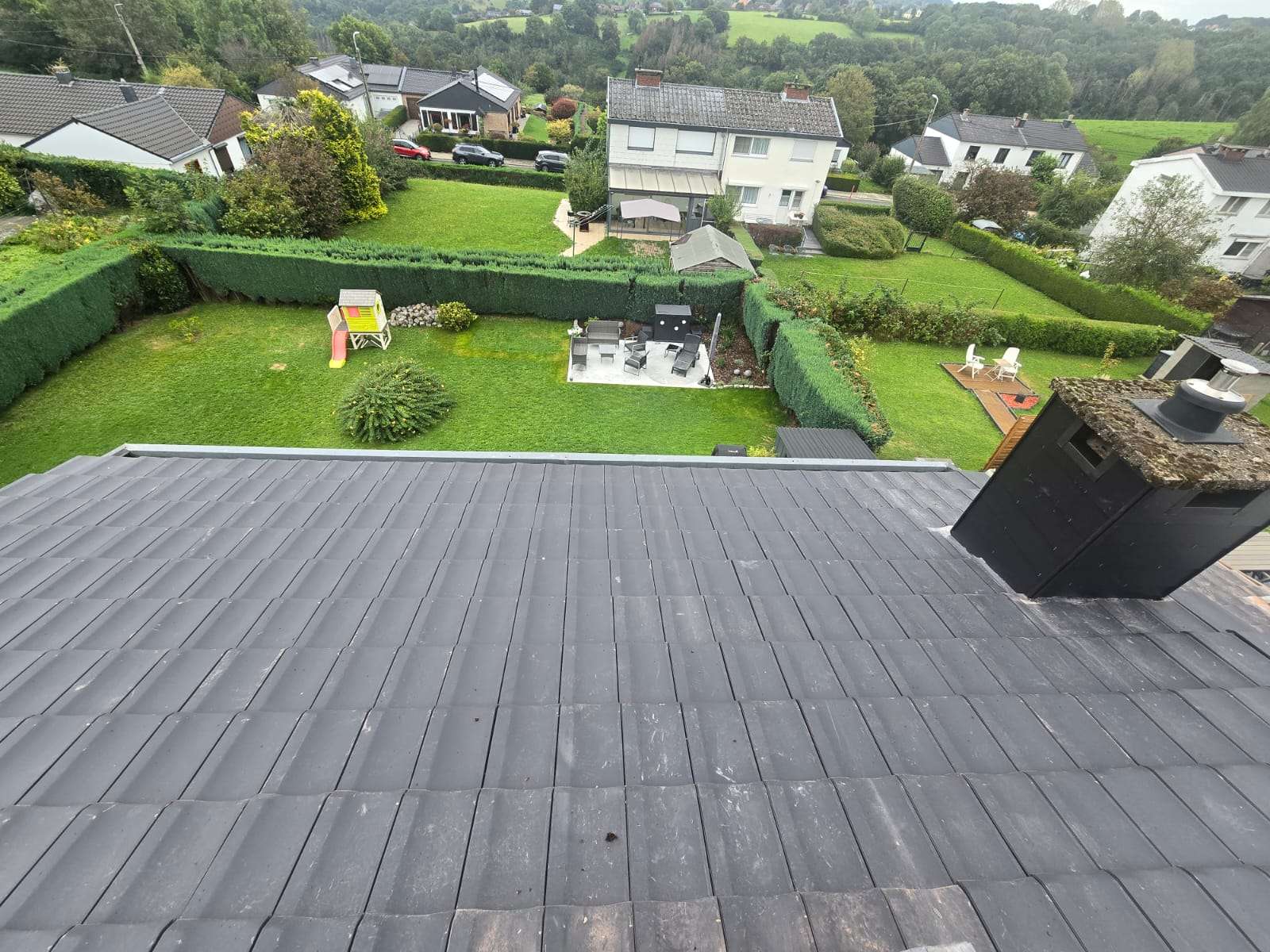 Toit en tuiles béton neuf, maison blanche et jardins en contrebas